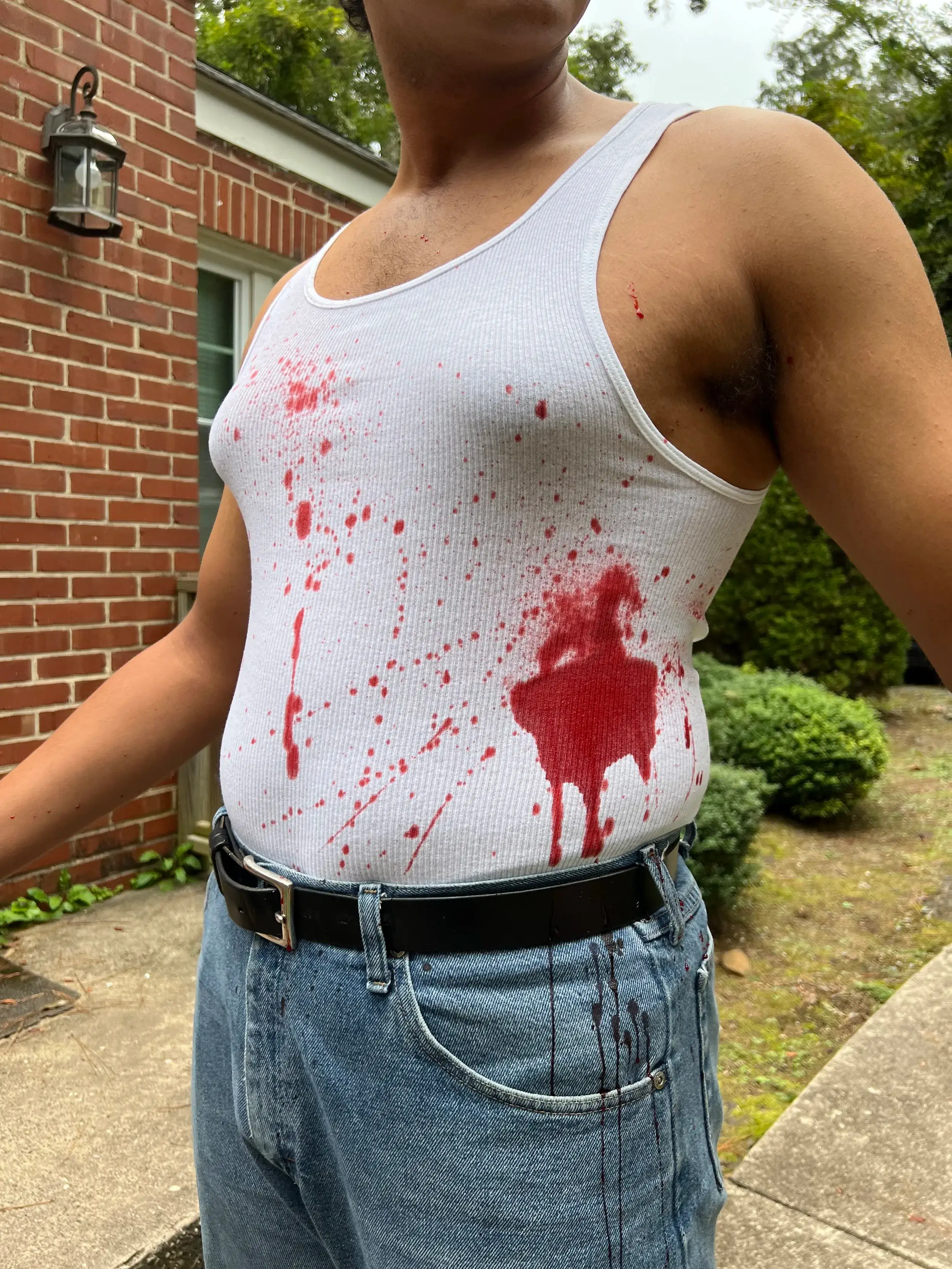 White tank top spattered with blood from a chest wound