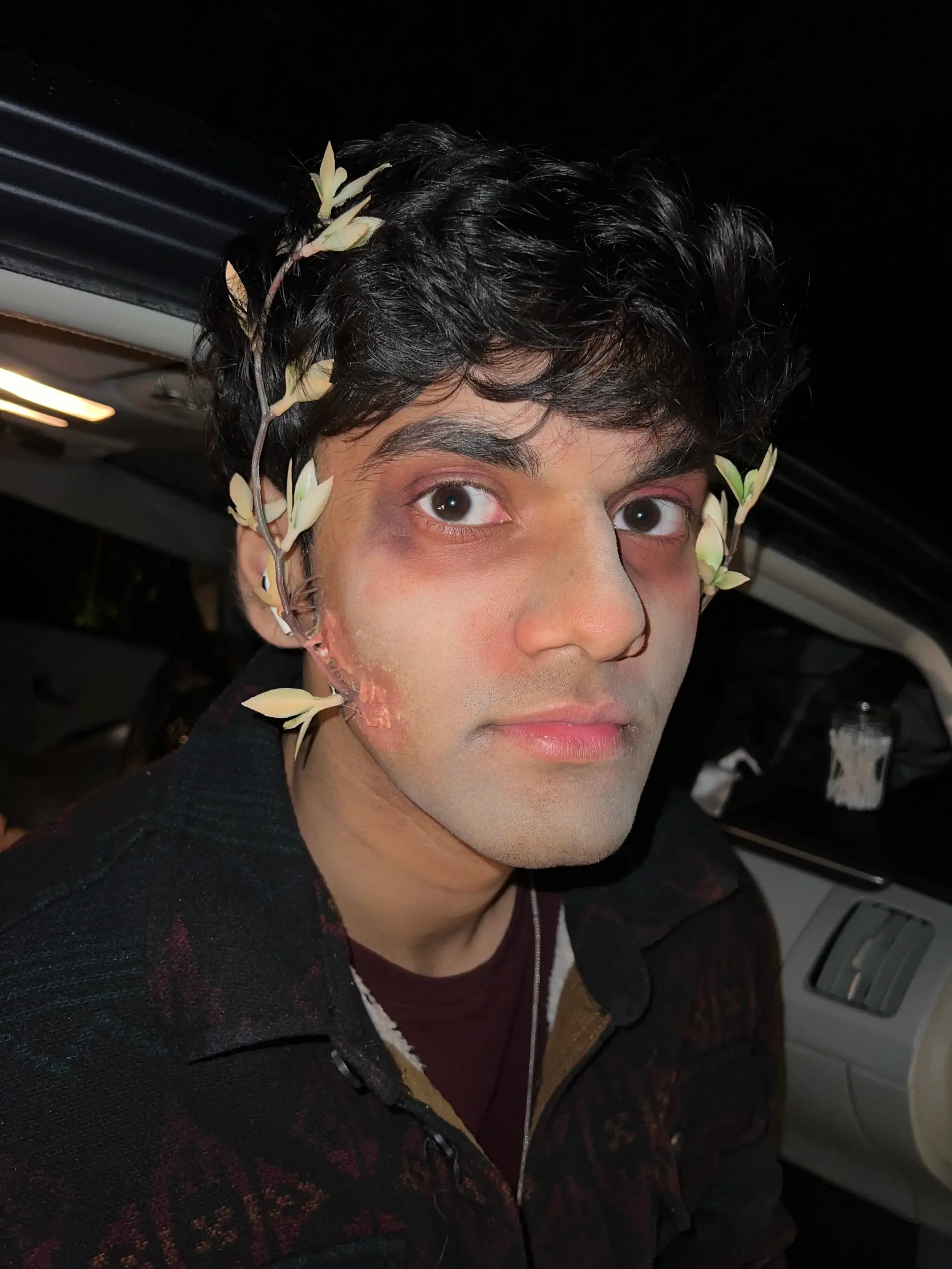 Man in a laurel wreath with a bruised, shadowed eye