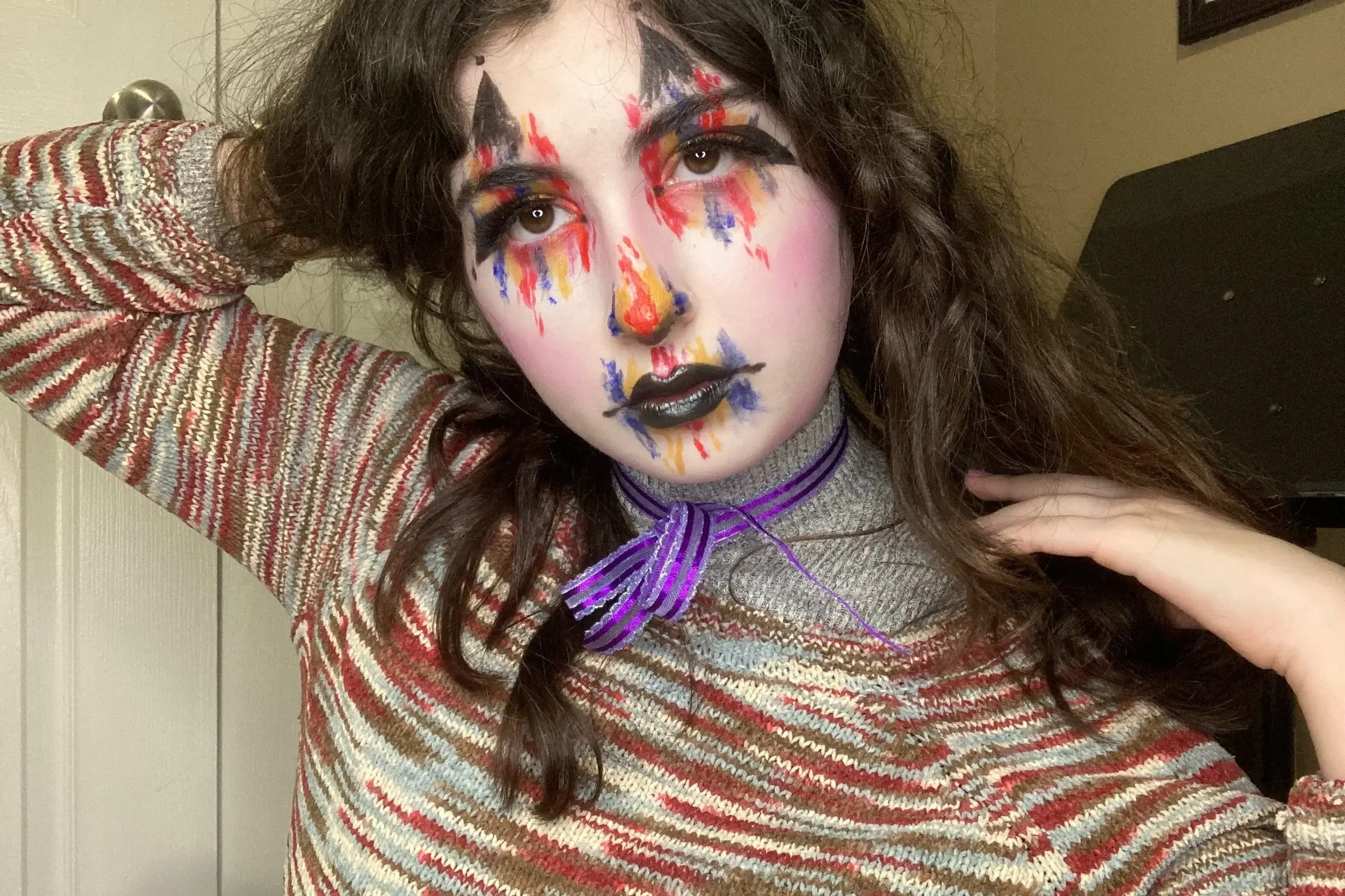 Glam clown makeup with rainbow drips running from the eyes