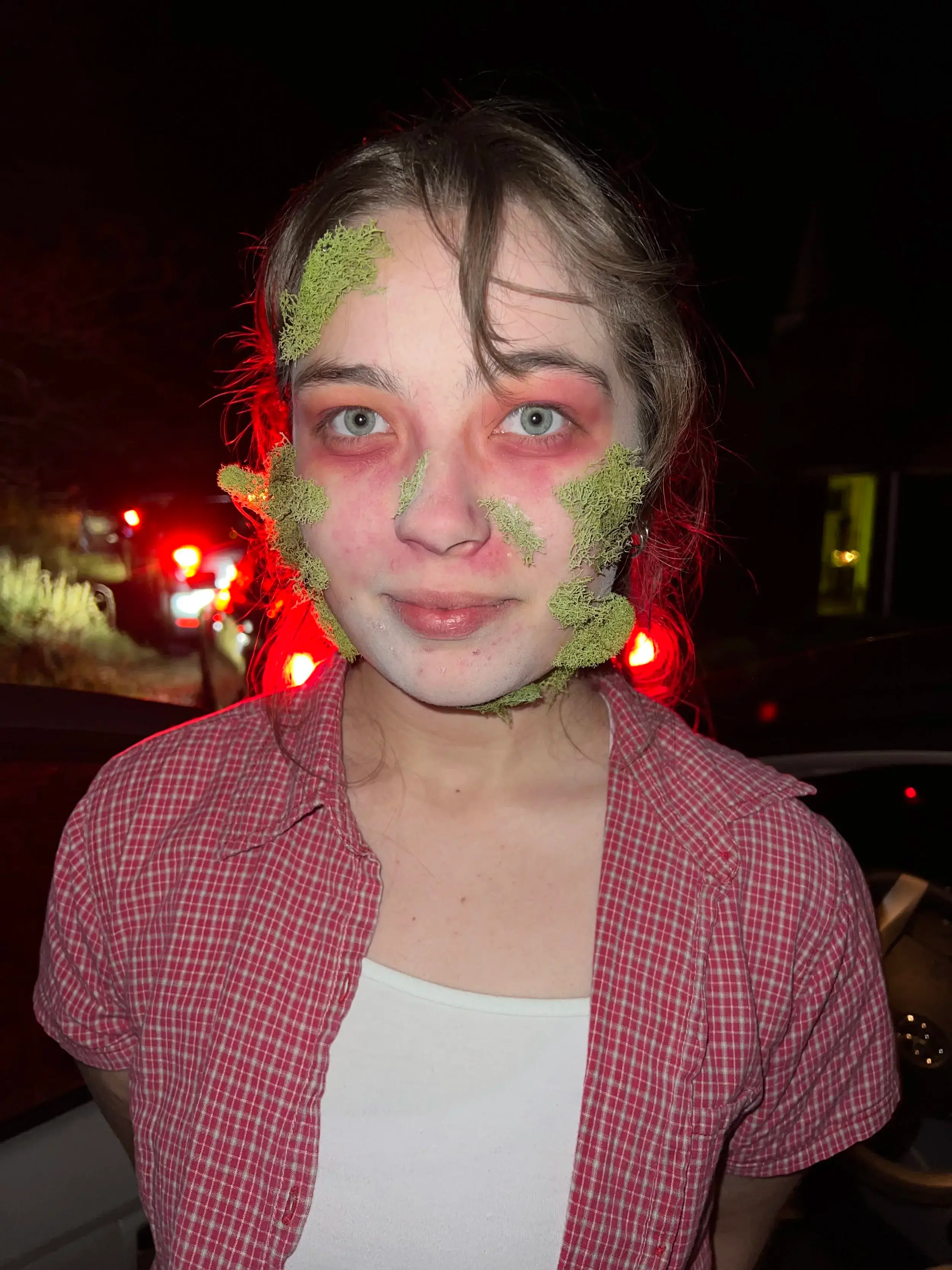 Green mossy decay spreading across a pale face with red-rimmed eyes