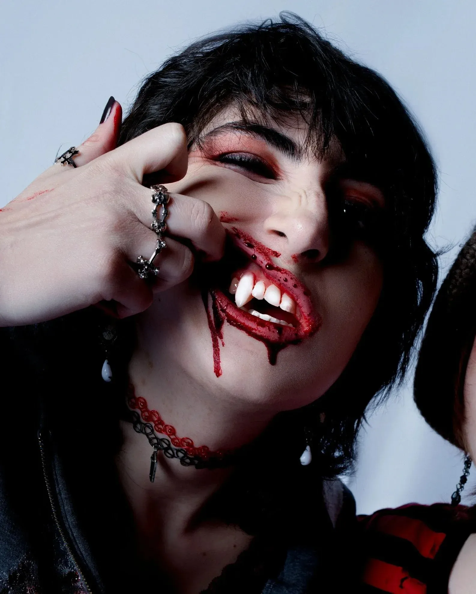 Vampire baring fangs with blood running from the mouth and a bitten, bleeding neck